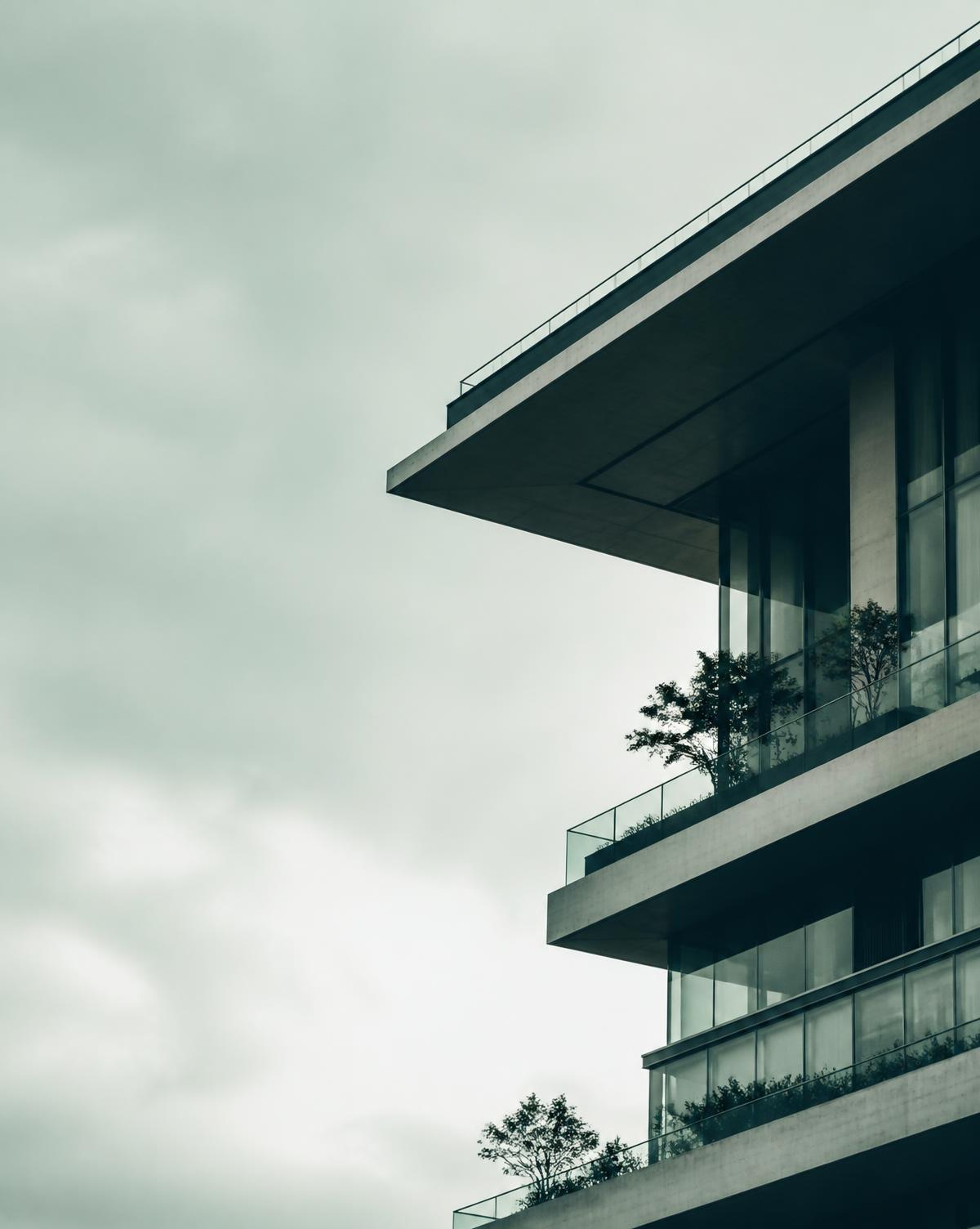 Concrete cantilever of a residential tower against an overcast sky